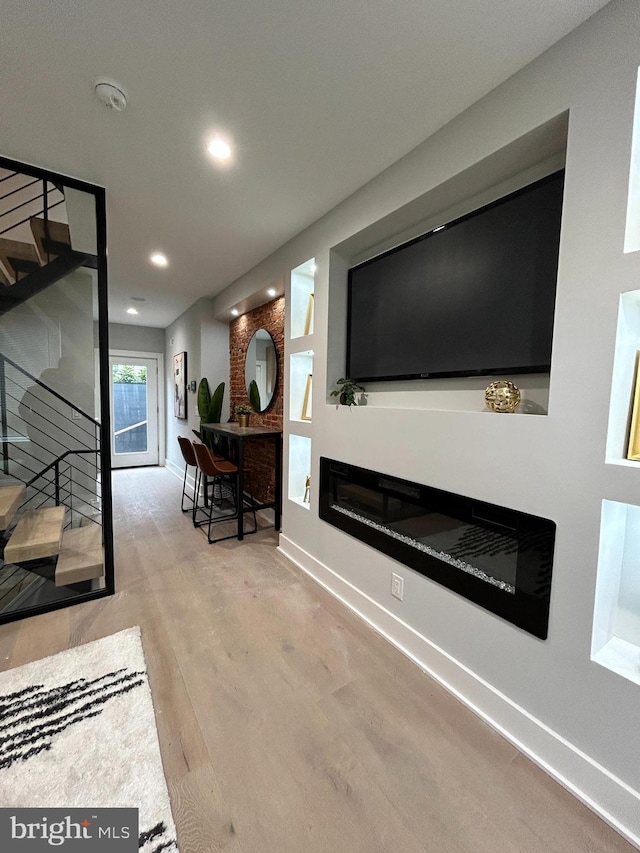 living room with a large fireplace and light hardwood / wood-style floors