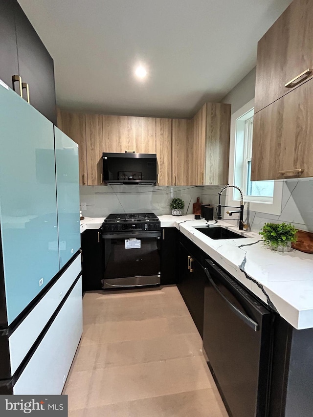 kitchen featuring sink, light stone countertops, stainless steel appliances, and tasteful backsplash