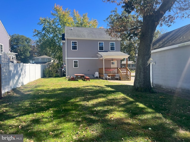 rear view of house with a deck and a lawn