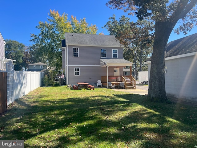 rear view of house with a yard and a deck