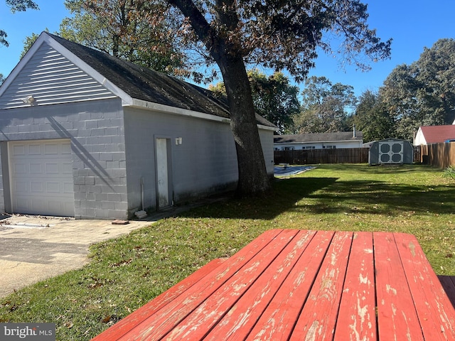 wooden deck featuring a garage, a shed, and a yard