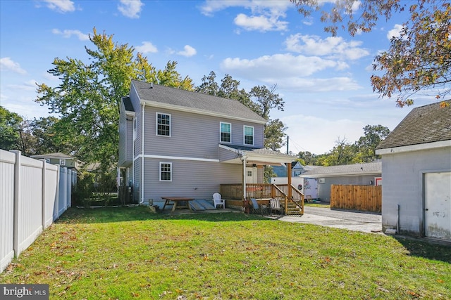 back of property with a yard and a deck