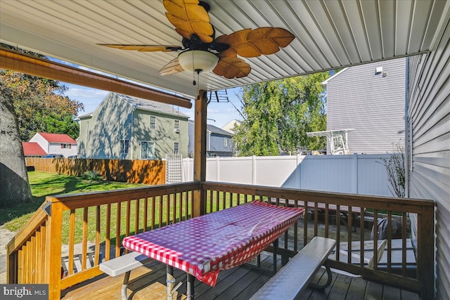 wooden terrace with a lawn and ceiling fan