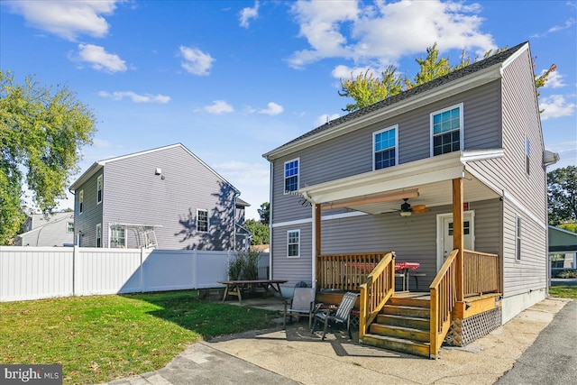 rear view of house featuring a patio, a deck, ceiling fan, and a lawn