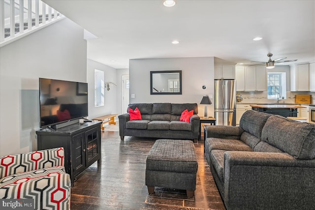 living room featuring ceiling fan, dark wood-type flooring, and sink