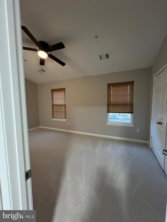 spare room featuring light carpet and ceiling fan