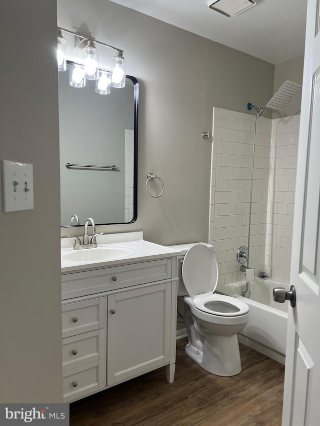 full bathroom featuring wood-type flooring, vanity, toilet, and tiled shower / bath