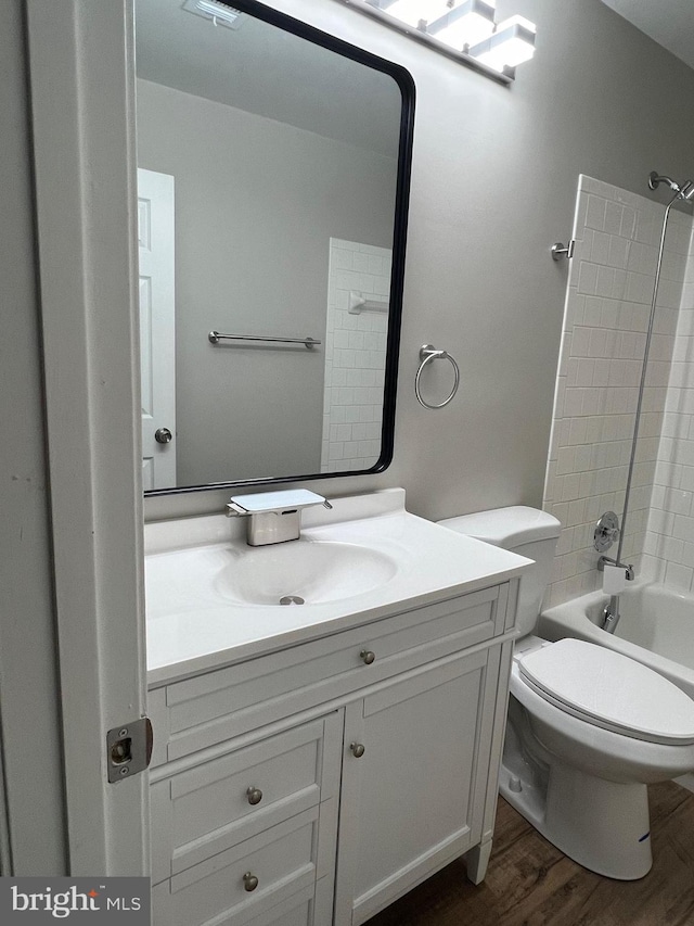 full bathroom with wood-type flooring, vanity, bathing tub / shower combination, and toilet