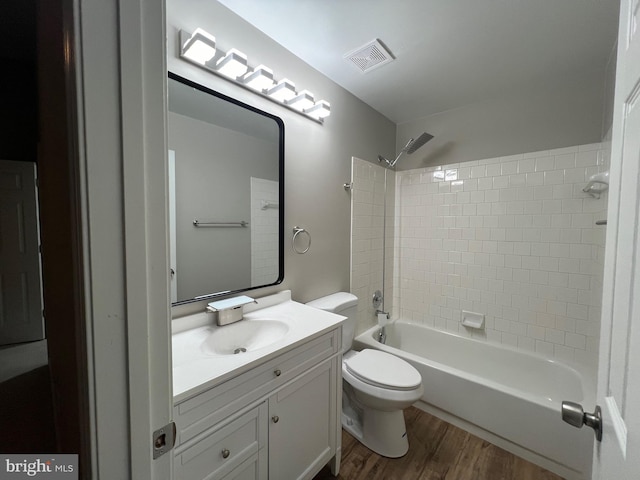 full bathroom featuring hardwood / wood-style floors, vanity, toilet, and tiled shower / bath