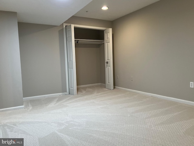 unfurnished bedroom featuring light carpet and a closet