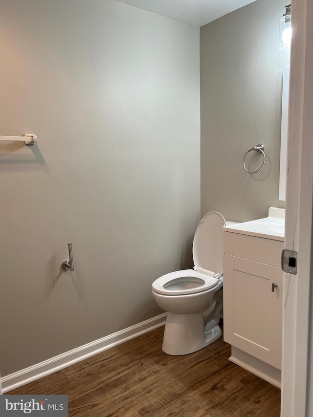 bathroom with hardwood / wood-style floors, vanity, and toilet