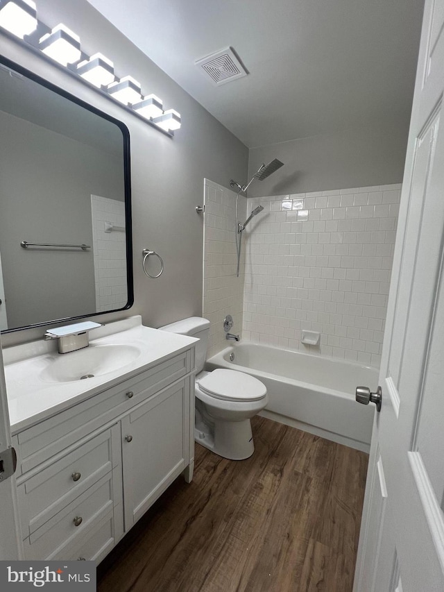 full bathroom featuring wood-type flooring, vanity, toilet, and tiled shower / bath