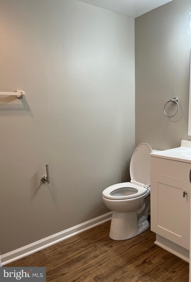 bathroom with vanity, wood-type flooring, and toilet