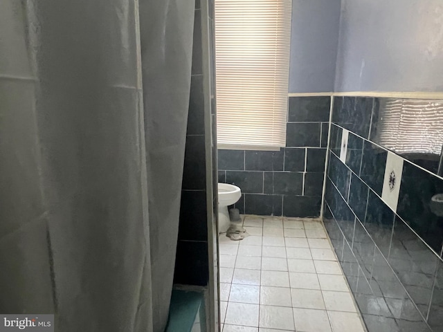 bathroom featuring tile patterned floors, tile walls, and a shower with shower curtain