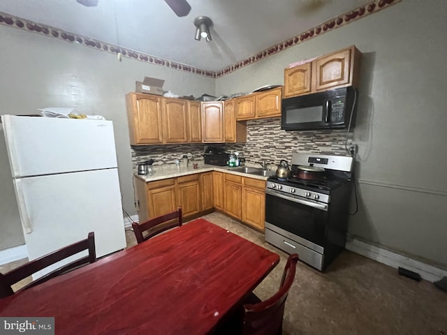 kitchen featuring sink, white refrigerator, tasteful backsplash, and stainless steel gas range