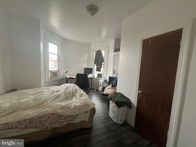 bedroom with cooling unit and dark wood-type flooring