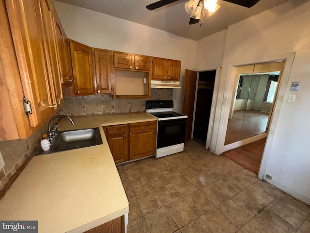 kitchen featuring electric range, sink, ceiling fan, decorative backsplash, and light tile patterned floors