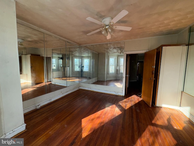 unfurnished room with ceiling fan and dark wood-type flooring