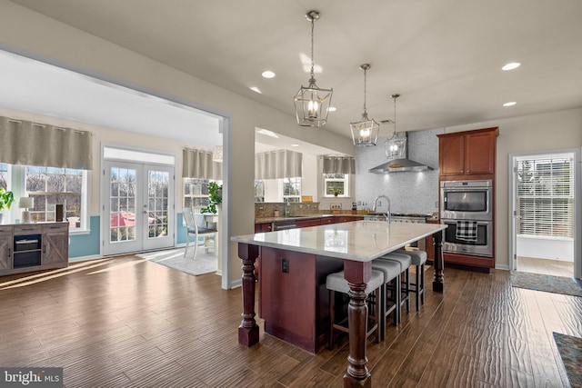 6616 Osborne Hill Dr, Upper Marlboro, MD 20772 - kitchen with wall chimney exhaust hood, stainless steel double oven, decorative backsplash, recessed lighting, and dark wood-style flooring