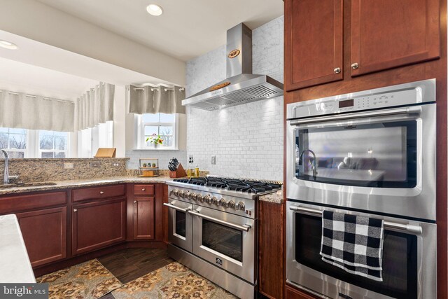 6616 Osborne Hill Dr, Upper Marlboro, MD 20772 - kitchen featuring stainless steel appliances, wall chimney range hood, a sink, and tasteful backsplash