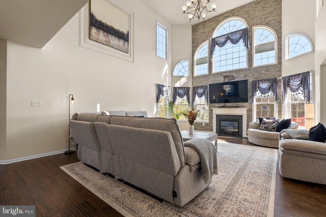 6616 Osborne Hill Dr, Upper Marlboro, MD 20772 - living area featuring a high ceiling, a chandelier, a glass covered fireplace, hardwood / wood-style flooring, and baseboards