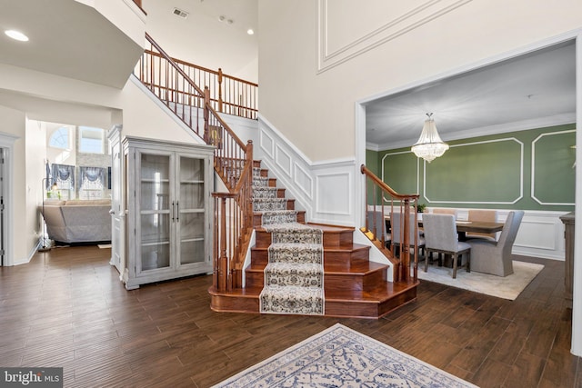 6616 Osborne Hill Dr, Upper Marlboro, MD 20772 - staircase with a decorative wall, a chandelier, wood finished floors, a towering ceiling, and a wainscoted wall