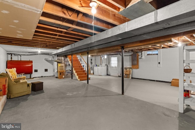 basement with washer and clothes dryer, electric panel, and heating unit