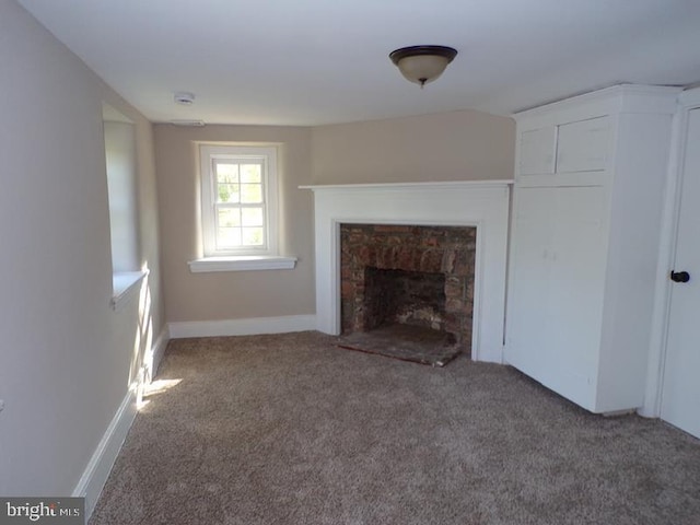 unfurnished living room featuring carpet floors and a stone fireplace