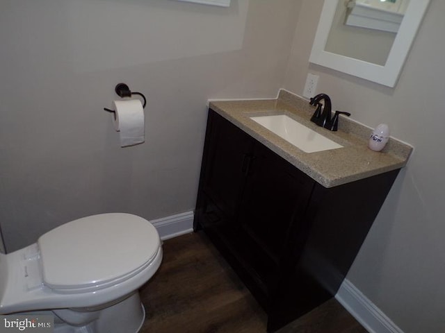 bathroom featuring vanity, wood-type flooring, and toilet