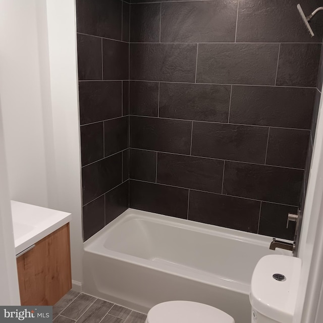 full bathroom featuring hardwood / wood-style flooring, vanity, toilet, and tiled shower / bath combo