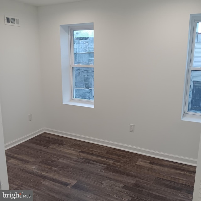 unfurnished room with dark hardwood / wood-style flooring