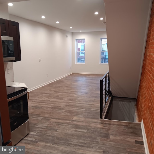 living room featuring dark wood-type flooring and brick wall