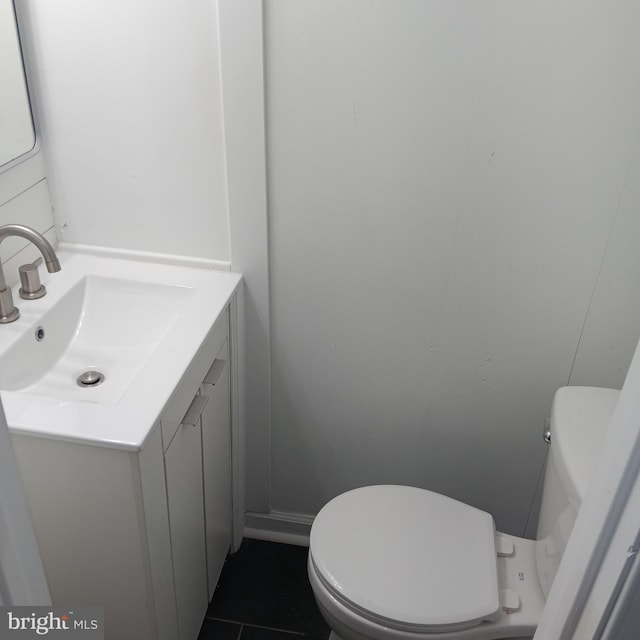 bathroom featuring tile patterned flooring, vanity, and toilet