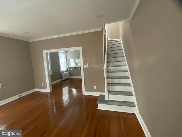 stairway featuring hardwood / wood-style flooring, ornamental molding, and radiator heating unit