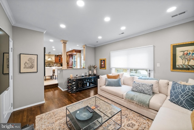 living room with decorative columns, crown molding, and dark wood-type flooring