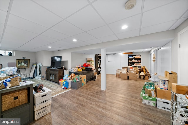 playroom with a drop ceiling and wood-type flooring