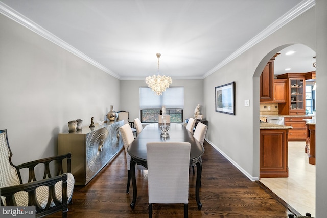 dining room with dark hardwood / wood-style floors, an inviting chandelier, and ornamental molding