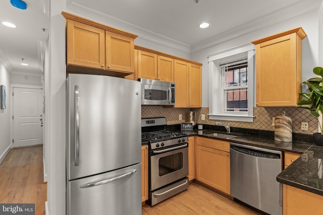 1408 10th St NW Unit 102, Washington, DC 20001 - kitchen with stainless steel appliances, crown molding, decorative backsplash, light wood-style flooring, and dark stone countertops