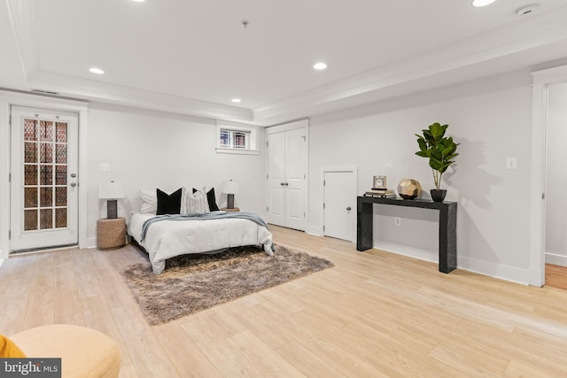 bedroom featuring hardwood / wood-style flooring and a tray ceiling