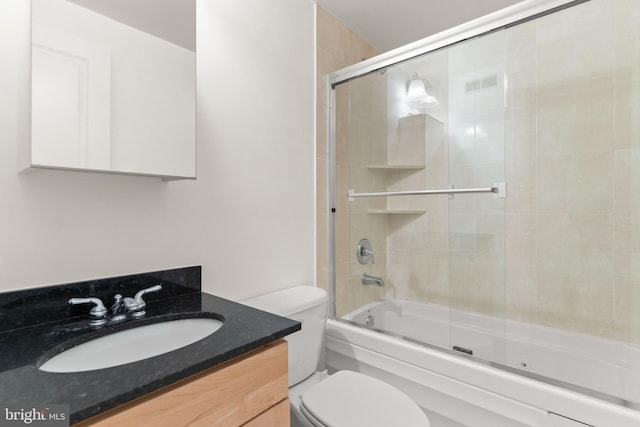 full bathroom featuring vanity, enclosed tub / shower combo, and toilet