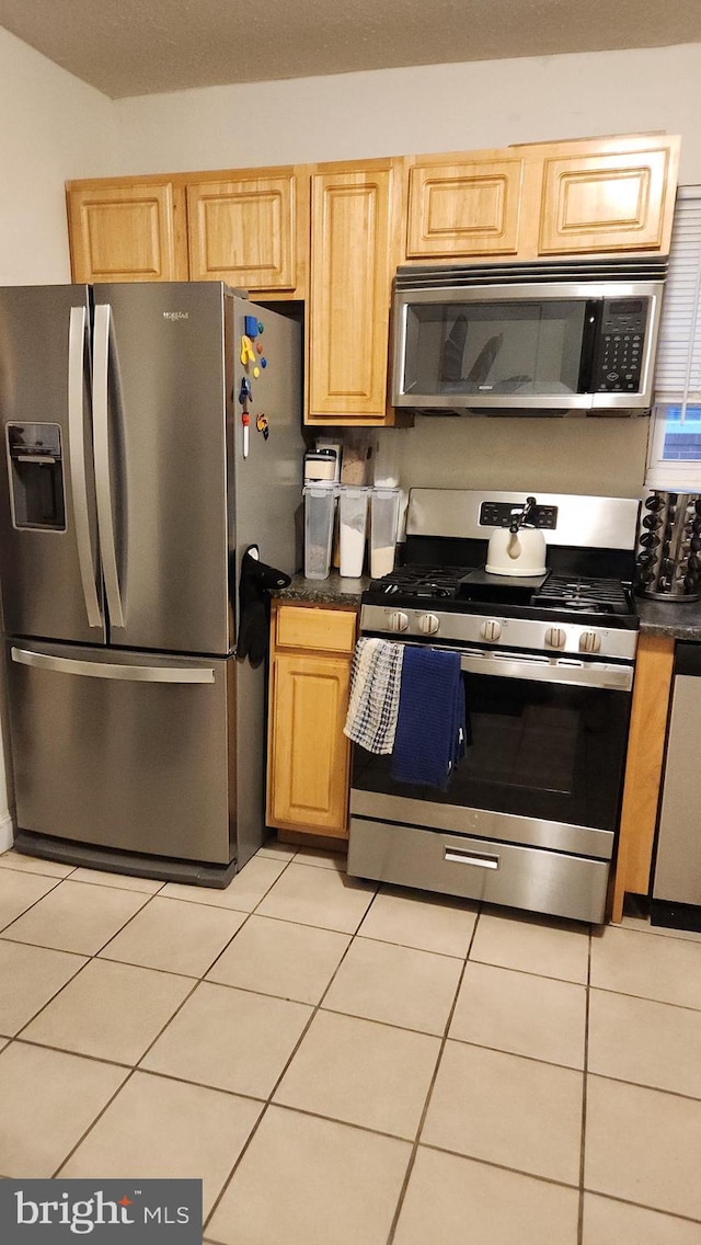 kitchen featuring light brown cabinetry, light tile patterned floors, and appliances with stainless steel finishes