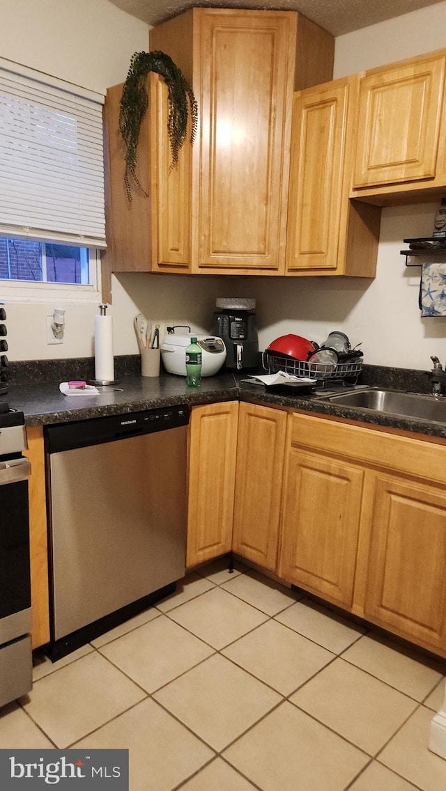 kitchen with light tile patterned floors, stainless steel appliances, and sink