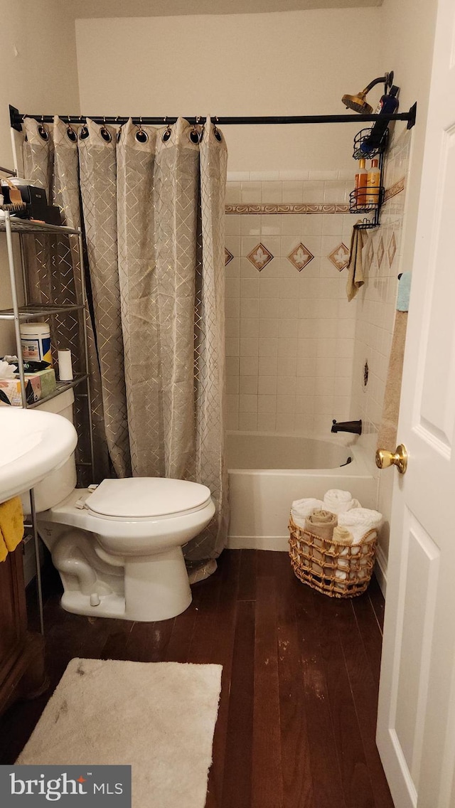 bathroom featuring hardwood / wood-style floors, toilet, and shower / bathtub combination with curtain