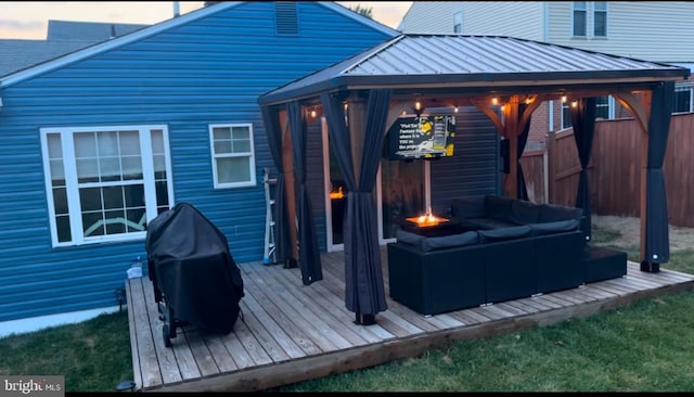 deck at dusk with a gazebo, grilling area, and an outdoor hangout area