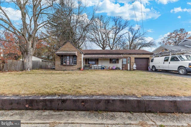 single story home featuring a front lawn and a garage