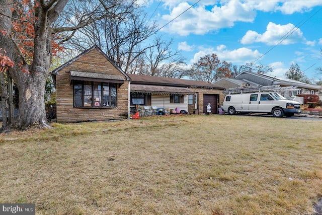 ranch-style home with a front lawn, stone siding, and an attached garage