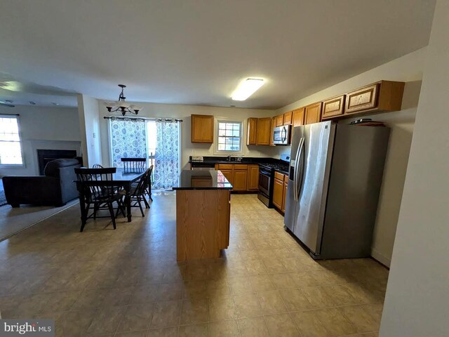 kitchen with a healthy amount of sunlight, hanging light fixtures, stainless steel appliances, and sink