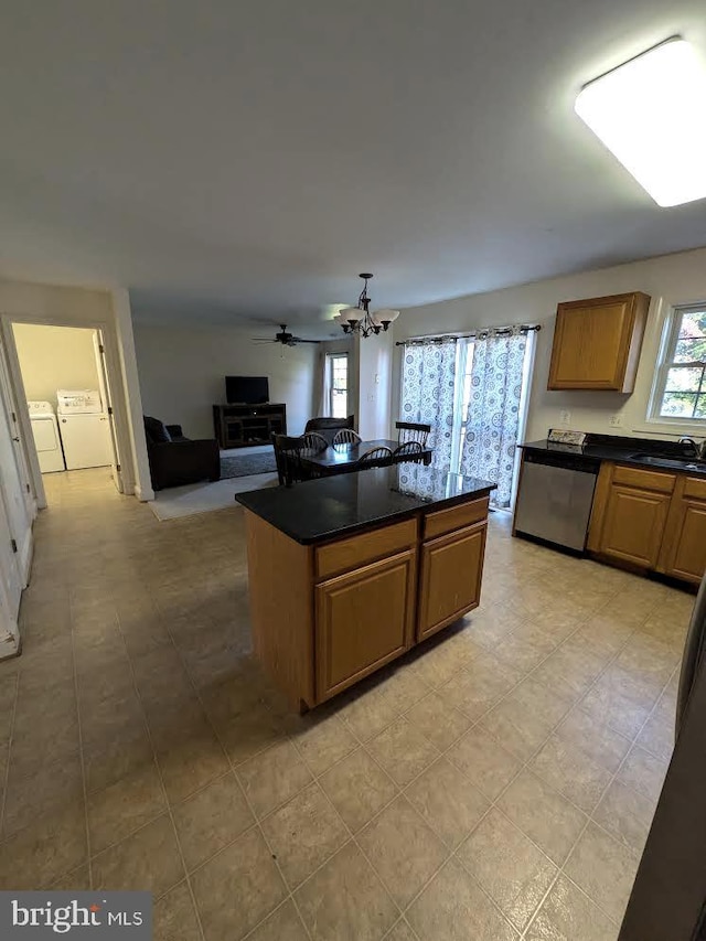 kitchen featuring dark stone counters, ceiling fan with notable chandelier, sink, dishwasher, and independent washer and dryer