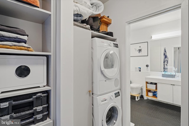 clothes washing area featuring stacked washer / drying machine