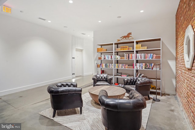 sitting room featuring brick wall